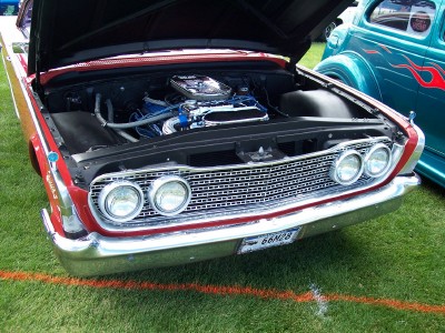 1972 Ford Ranchero - A red classic car's engine is exposed, parked next to a blue custom car at an outdoor event.