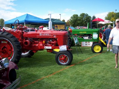 1972 Ford Ranchero - Two vintage tractors, a red Farmall and a green John Deere, are displayed at an outdoor event.