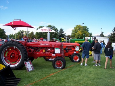 1972 Ford Ranchero - A red Farmall tractor is displayed at an outdoor event, with other tractors and attendees visible.