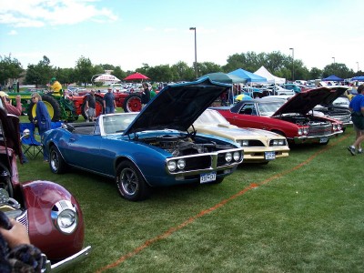 1972 Ford Ranchero - A collection of vintage automobiles are displayed on a grassy field under a partly cloudy sky.