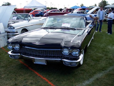 1972 Ford Ranchero - A black convertible is displayed at an outdoor car show with other vehicles and tents in the background.