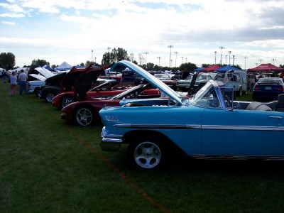 1972 Ford Ranchero - A variety of vintage automobiles are displayed on a grassy field under a partly cloudy sky.
