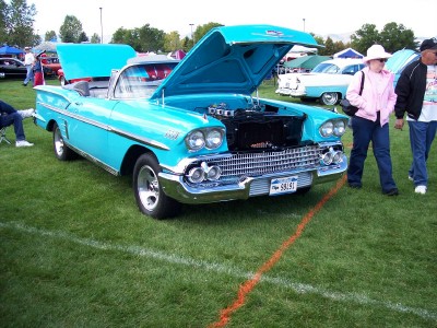 1972 Ford Ranchero - Turquoise 1958 Chevrolet Impala convertible on display at a car show, engine visible under the open hood.