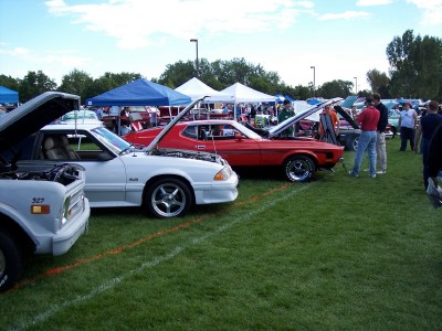 1972 Ford Ranchero - A red Ford Mustang from the early 1970s is displayed with its hood up at an outdoor car show.