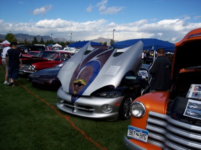 1972 Ford Ranchero - A silver sports car with a distinctive hood design is displayed at an outdoor car show.