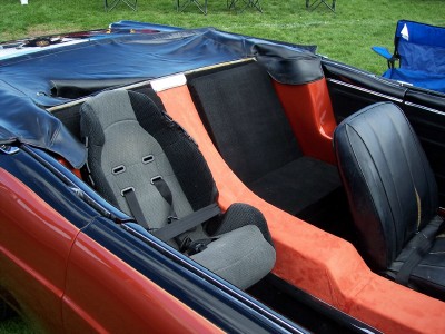 1972 Ford Ranchero - The interior of a custom convertible features a child seat and unique orange and black upholstery.