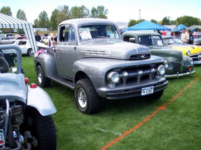 1972 Ford Ranchero - A classic Ford pickup truck is displayed at an outdoor event with other vehicles in the background.
