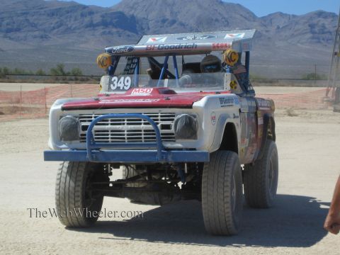 1990 Ford Bronco - red-and-white early Ford Bronco built as a race truck and numbered 349 sits on a desert course.