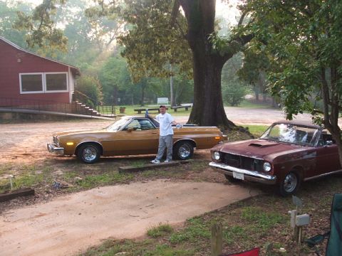 1966 Ford Ranchero - Two classic pickup trucks are parked outdoors near a building and a large tree.
