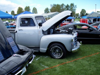 1972 Ford Ranchero - A classic silver pickup truck from the 1950s is displayed with its hood open at an outdoor car show.