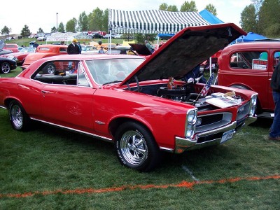 1972 Ford Ranchero - A red 1966 Pontiac GTO is displayed with its hood open at an outdoor car show.