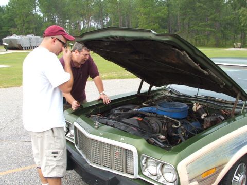1966 Ford Ranchero - Two men inspect the engine of a green 1972 Ford Torino, its hood raised for a closer look.