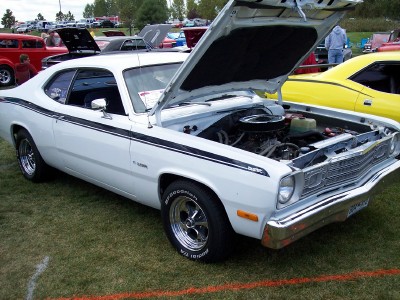1972 Ford Ranchero - A white 1972 Plymouth Duster is displayed with its hood open, revealing the engine bay.