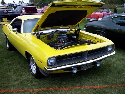 1972 Ford Ranchero - A yellow 1970 Plymouth Barracuda is displayed with its hood open, showing the engine compartment.