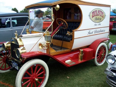 1972 Ford Ranchero - A vintage white and red Ford Model T van, likely from the 1910s, is displayed at an outdoor event.