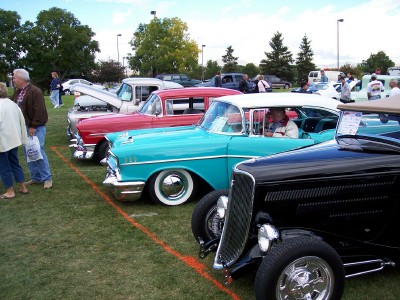 1972 Ford Ranchero - A row of classic cars, including a turquoise 1957 Chevrolet Bel Air, are displayed on a grassy field.