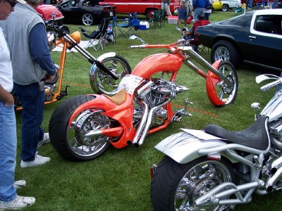 1972 Ford Ranchero - Several custom choppers are parked on the grass at an outdoor car show.