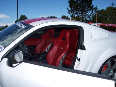 1972 Ford Ranchero - The interior of a white car features red racing seats with "CORSA" branding and red stripes on the roof.