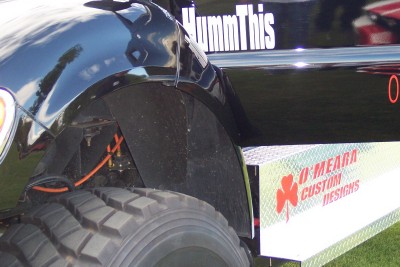 1972 Ford Ranchero - Close-up of a black truck's rear wheel well and custom bed modifications, including text and a logo.