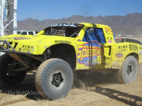 1990 Ford Bronco - bright yellow Speedway-liveried number 5 off-road race truck with BFGoodrich and King decals charges through a dusty turn.