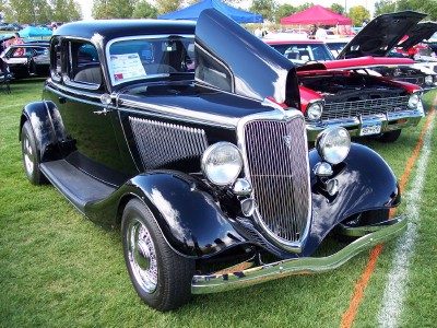 1972 Ford Ranchero - A black 1934 Ford coupe is displayed with its hood open at an outdoor car show.