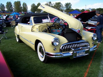 1972 Ford Ranchero - Yellow 1947 Buick convertible on display with hood open at an outdoor car show.