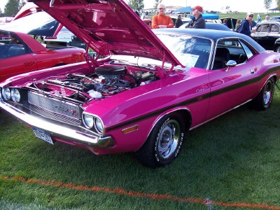 1972 Ford Ranchero - Pink 1970 Dodge Challenger at a car show with its hood open, showing the engine.