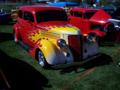 1972 Ford Ranchero - A customized sedan with flame paint sits on display at an outdoor car show.