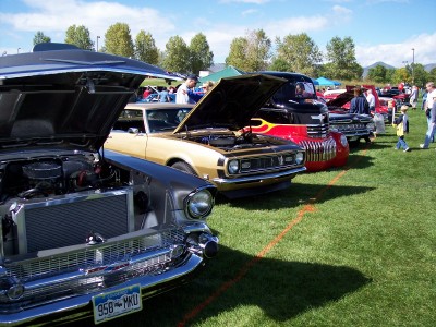 1972 Ford Ranchero - Several classic cars are on display at an outdoor event, with hoods raised to show off engines.