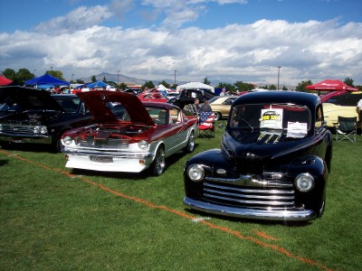 1972 Ford Ranchero - A classic black pickup truck from the 1940s is displayed at an outdoor car show with other vehicles present.