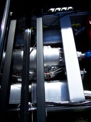 1972 Ford Ranchero - Close-up view of engine parts, showing a supercharger and exhaust system behind a protective cage.