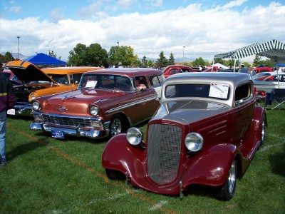 1972 Ford Ranchero - Multiple custom vehicles displayed at a car show under a partly cloudy sky.