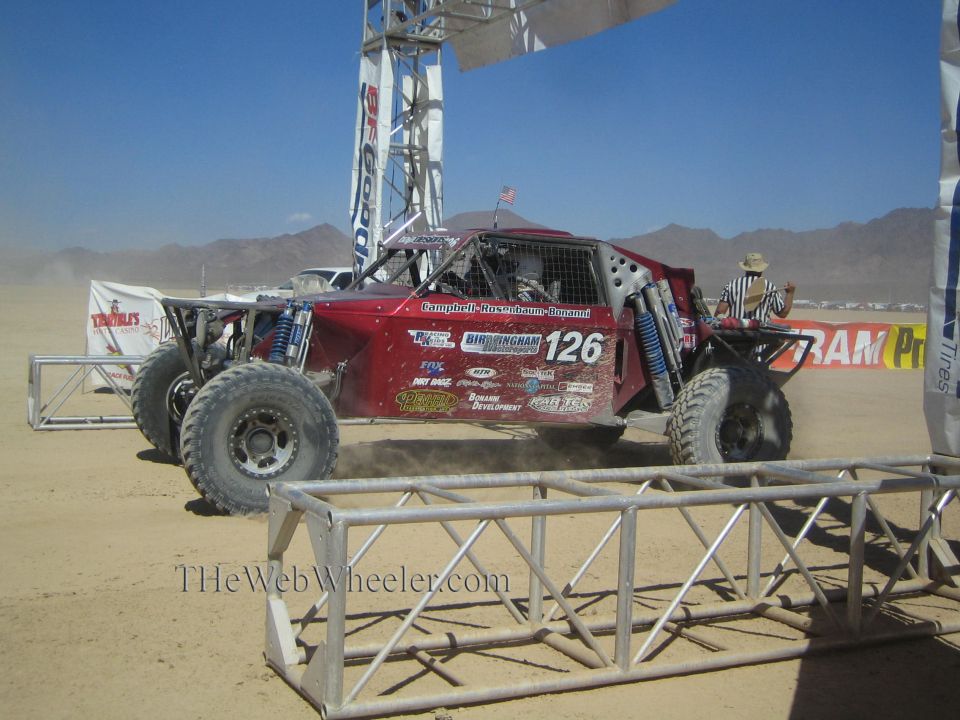 Dark red off-road race buggy #126 at desert start under BFGoodrich arch