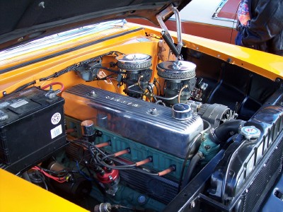 1972 Ford Ranchero - Engine bay of a yellow vehicle, chrome valve covers and dual carburetors.
