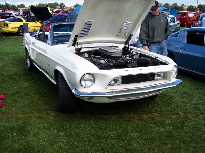 1972 Ford Ranchero - A white 1967-1968 Ford Mustang convertible is displayed with its hood open at an outdoor car show.