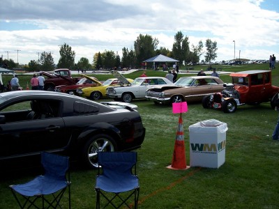 1972 Ford Ranchero - Various vehicles are displayed on a grassy field under a cloudy sky at an outdoor event.