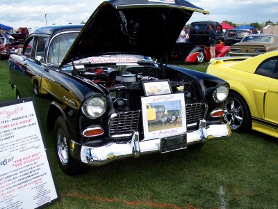 1972 Ford Ranchero - A black 1955 Chevrolet Bel Air is displayed with its hood up at an outdoor car show.