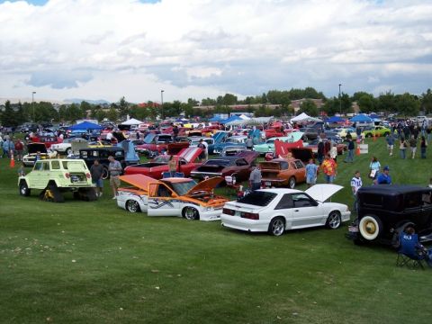 1972 Ford Ranchero - A large gathering of cars and people at an outdoor event, with tents and trees in the background.