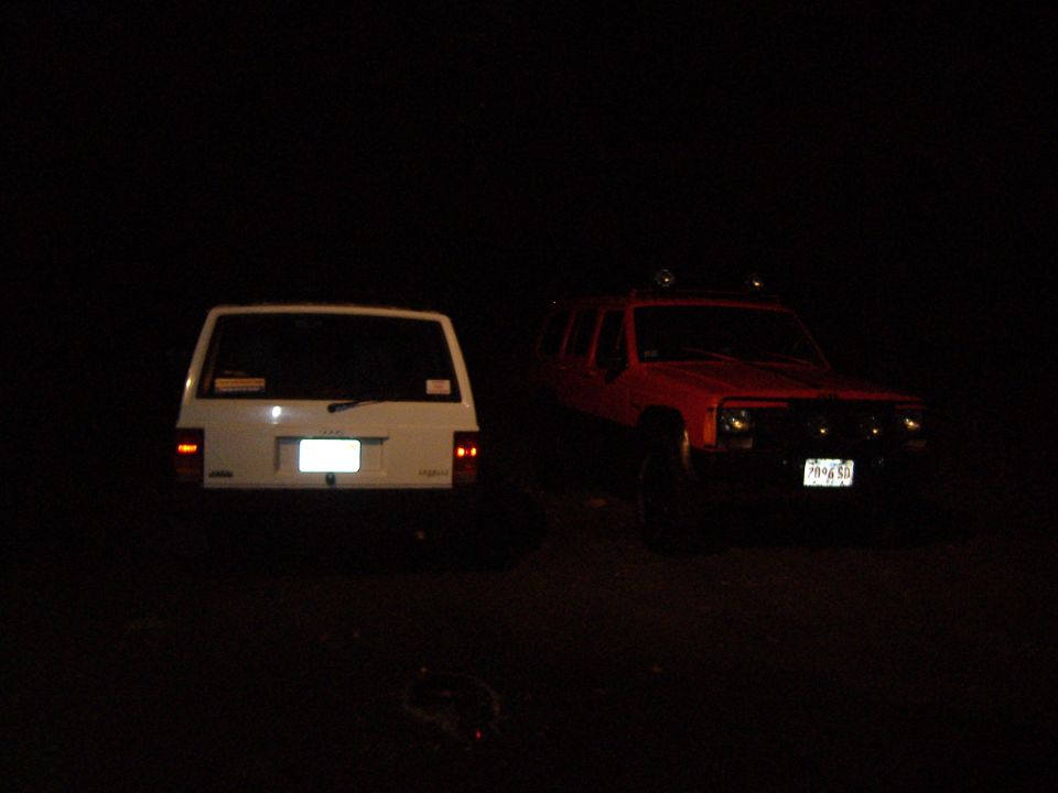 1990 Jeep Cherokee rear view next to another Jeep Cherokee at night
