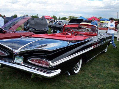 1972 Ford Ranchero - A black 1959 Chevrolet Impala convertible with a red interior is displayed at an outdoor event.