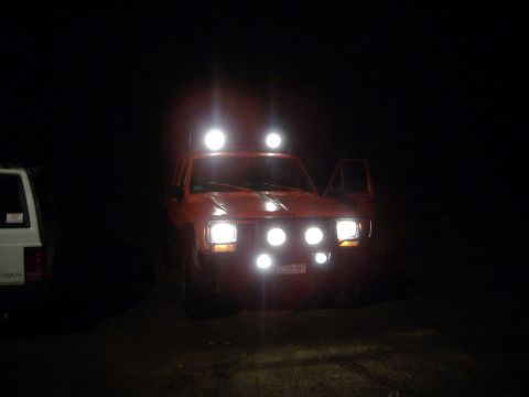 1990 Jeep Cherokee - Nighttime photo of an orange 1990 Jeep Cherokee equipped with multiple auxiliary lights.