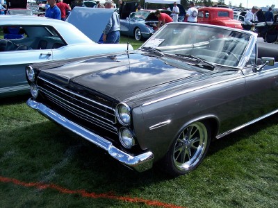 1972 Ford Ranchero - A dark gray convertible with a distinctive chrome grille is displayed at an outdoor event.