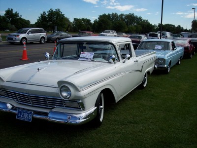 1972 Ford Ranchero - A white 1957 Ford Ranchero pickup truck is parked on a grassy field next to other vehicles.