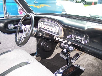 1972 Ford Ranchero - The interior of a classic car features a custom steering wheel, a period-correct radio, and additional gauges below the dashboard.