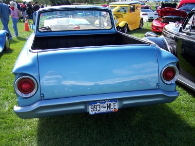 1972 Ford Ranchero - A light blue pickup truck is parked on a grassy field with other vehicles around it.