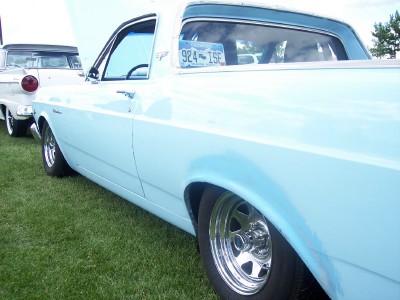 1972 Ford Ranchero - A light blue 1972 Ford Ranchero is parked on grass, showing its side profile and chrome wheels.