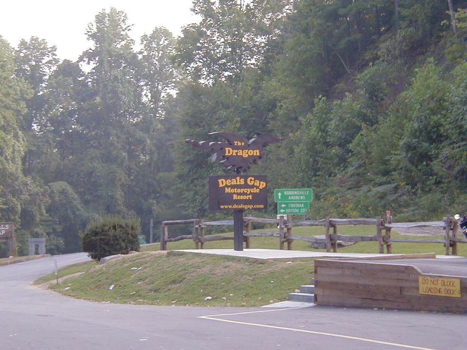 Motorcycle parked near a sign for The Dragon at Deals Gap Motorcycle Resort