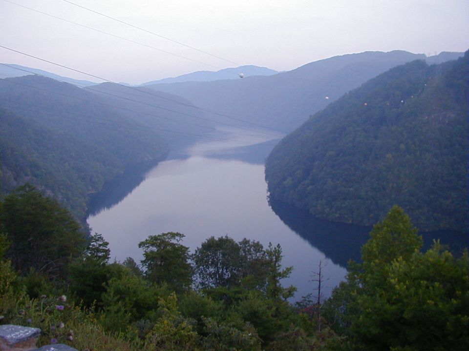 River winding through a mountain valley with power lines overhead