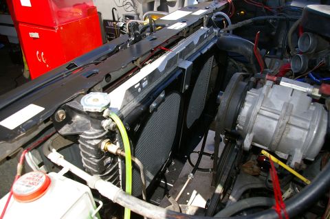 1986 Ford Bronco - Close-up view of the radiator and electric fans within a vehicle's engine bay.