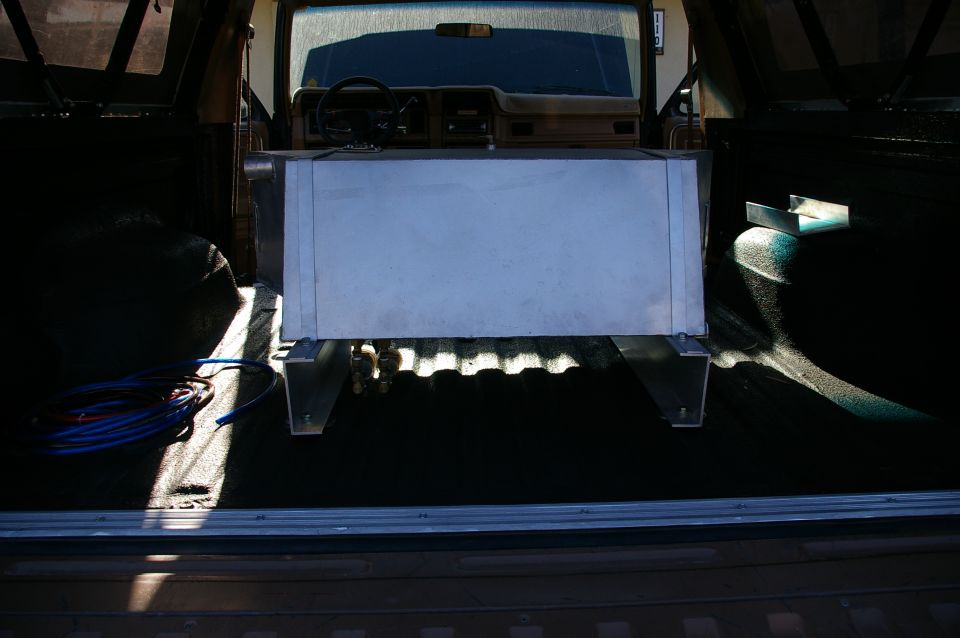 Auxiliary fuel tank mounted in the cargo area of a 1980s Ford Bronco, viewed from the rear
